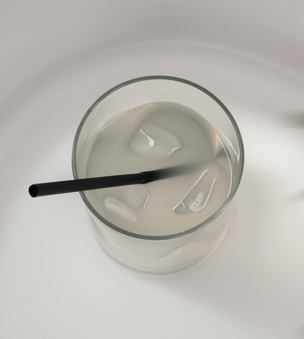 Top view of a 6-inch Black Cocktail hemp straw in a short glass of water