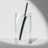 8-inch black compostable hemp straw in a glass of water