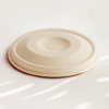 Compostable cup lid with straw hole made from upcycled hemp fiber, ideal for cold drinks.