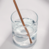6-inch natural brown compostable hemp straw in a short glass of water